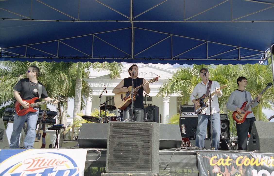 Tim McGeary on an outdoor festival stage with his band